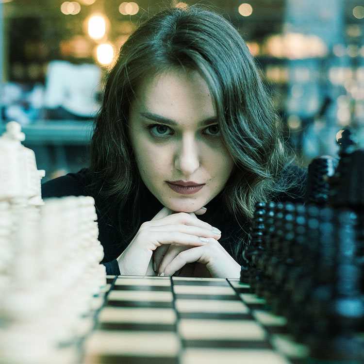 kobieta patrząca na planszę szachów