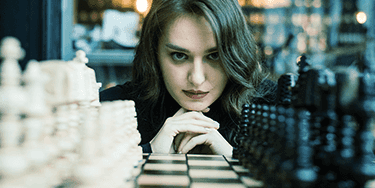 kobieta patrząca na planszę szachów